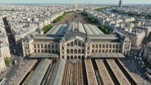Clock tower and train station view in Paris with bustling city life and river visible in the background