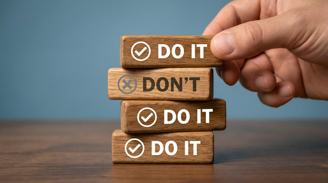 Hand stacking wooden blocks with 'Do It' and 'Don't' messages, decision making concept