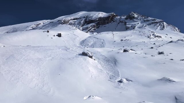 Avalanche aftermath on a steep mountain slope in winter, risk danger