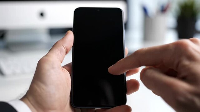 Male hand interacts with smartphone screen in a modern office setting, showcasing a series of gestures on the device with a blurred background of office equipment