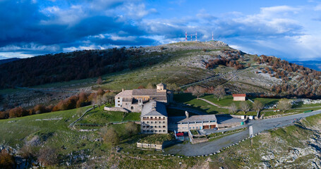 Fototapeta premium Aerial drone view of the autumn landscape surrounding the beech forest and the Sanctuary of San Miguel de Excelsis in the Sierra de Aralar. Huarte-Araquil, Navarre, Spain, Europe