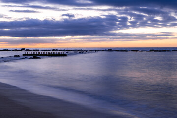 Obraz premium Amazing colourful sunrise seen over the Mediterranean Sea from Barceloneta Beach, which is located next to Barcelona's classic fishing quarter. It is the cities oldest and best-loved beach and gives w