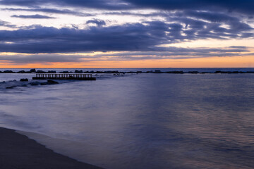 Obraz premium Amazing colourful sunrise seen over the Mediterranean Sea from Barceloneta Beach, which is located next to Barcelona's classic fishing quarter. It is the cities oldest and best-loved beach and gives w