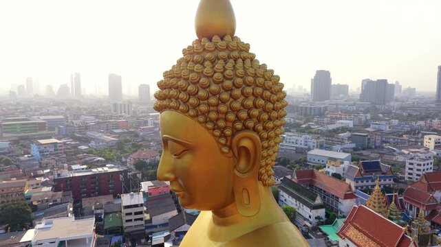 Aerial view of giant golden Buddha statue at Wat Paknam temple in Bangkok, Thailand. Monumental Buddhist landmark overlooking the city skyline in Southeast Asia.