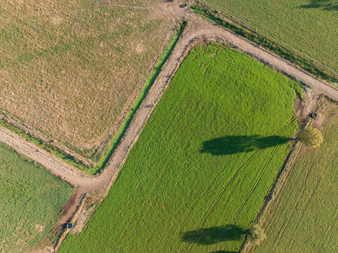 Aerial view of a zig zagging country road around green paddocks