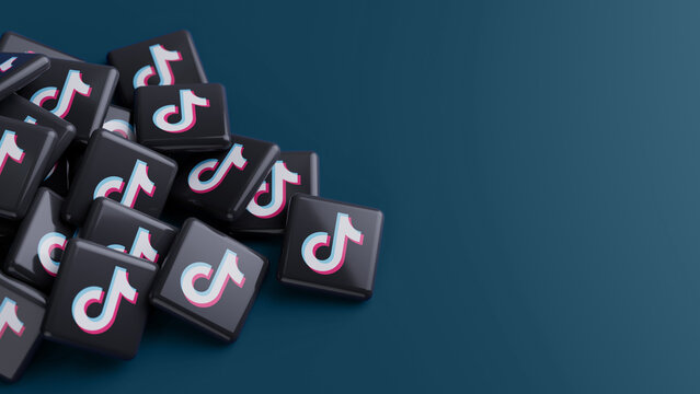 Berlin, Germany - February 24, 2026: Logo of the social media video platform TikTok in a pile on blue background with copy space
