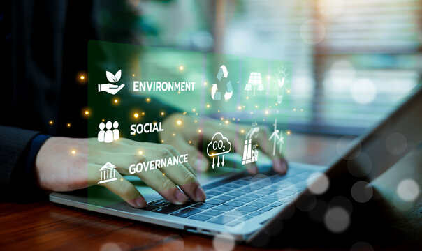 ESG sustainability business concept with digital interface showing Environment, Social, and Governance icons on laptop screen. Renewable energy, corporate responsibility, and green strategy.