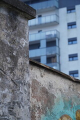 Kontrast między starym zniszczonym murem a nowoczesnym budynkiem mieszkalnym © bilcka
