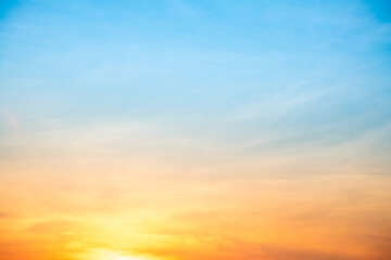 Fototapeta premium Sunset or sunrise sky with a vibrant gradient of orange, gold, and soft blue. Clear atmosphere with wispy clouds. Peaceful, natural light background. hope, freedom, new day and inspirational Concepts