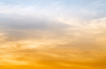 Obraz premium Sunset or sunrise sky with a vibrant gradient of orange, gold, and soft blue. Clear atmosphere with wispy clouds. Peaceful, natural light background. hope, freedom, new day and inspirational Concepts