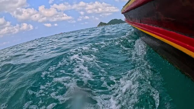 Thailand longtail boat slicing through turquoise waters, foam trailing behind, with distant island Koh Nang Yuan, and fluffy clouds in the sky, thrilling sea journey unfolds