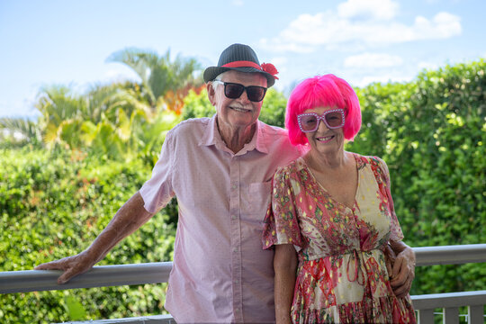 happy senior couple, wearing a fun pink wig and glasses