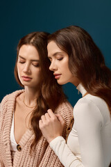 Twin sisters embracing tranquility and warmth in a serene studio moment