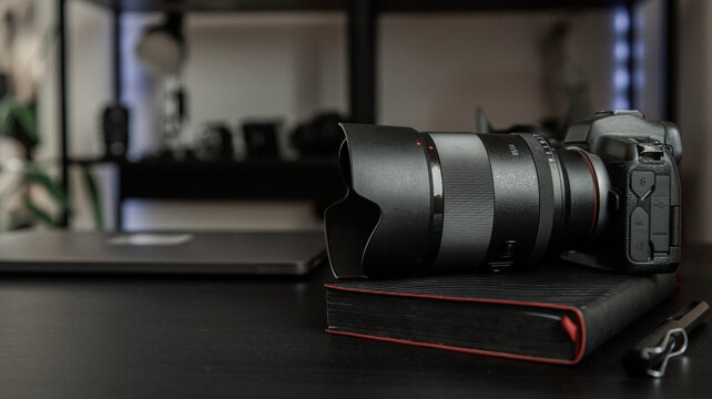 Professional camera and lens resting on a notebook, ready for creative work