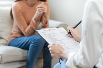 Obraz na płótnie Canvas Young woman in a mental therapy session talking with a psychologist in the office.