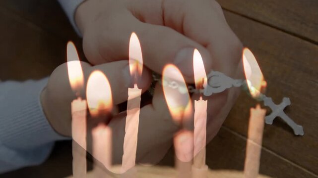 Composite video of candles blowing off against close up of woman hands with rosary praying
