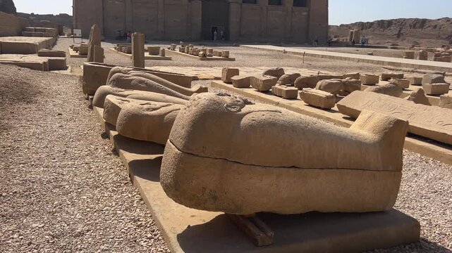 View of stone sarcophagi and the Temple of Hathor at Dendera, Egypt.