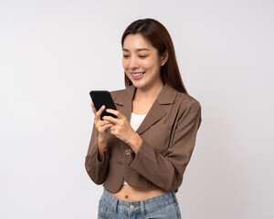 Fototapeta premium Pretty young asian woman using cellphone standing on isolated white background. Happy Excited Beautiful young asian shopping online payment with mobile phone. Playing game on smartphone