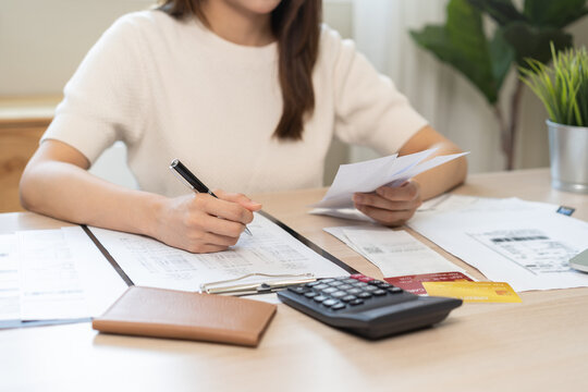 Deduction planning, debt asian young woman calculating money balance of finance from bill and income, cost budget expenses for pay money form personal individual on table at home. Financial concept.