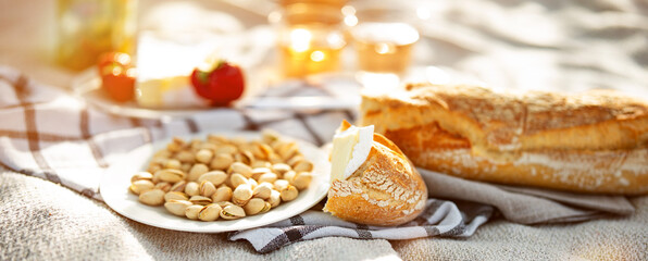 White plate filled with salted pistachios. Healthy snack, perfect for a picnic outdoors. Food photography with short depth of field.