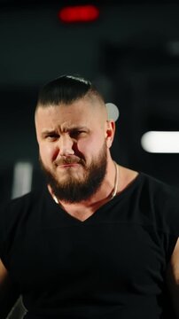 Close-up portraits of a muscular bearded man in a gym, captured in first and last frames, showing intense focus and grit during a strength workout under moody, dramatic lighting.