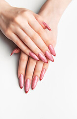 Female hands showing long pink glitter stiletto nails