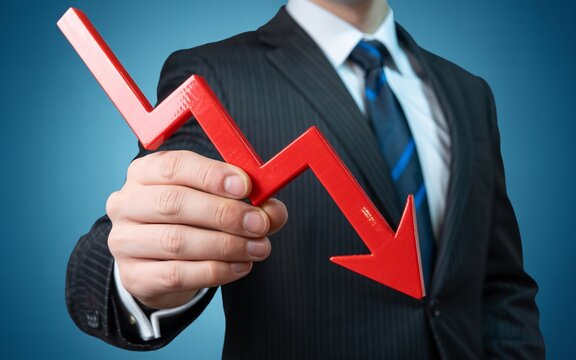 Businessman holding red arrow graph showing market downturn trend concept