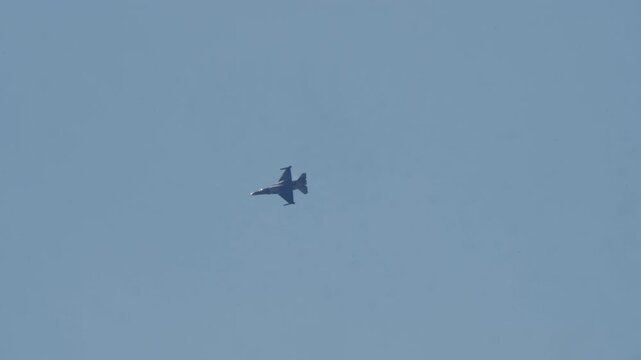 LUQA, MALTA - SEPTEMBER 28, 2025: Video footage of a military fighter jet performing a graceful banking turn against a vast, clear blue sky. A powerful display of aviation technology, speed, and