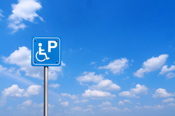 A handicapped parking sign with a bright blue sky background