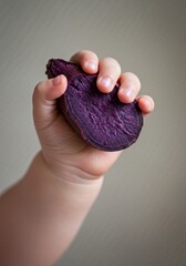 Baby's Hand Holding a Purple Sweet Potato