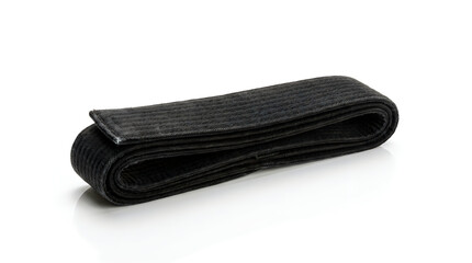 Black woven fabric belt rolled up on plain white surface