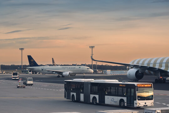 Ground Operations and Commercial Aircraft at Frankfurt International Airport during Sunset, Germany.