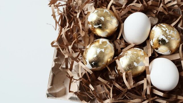 Decorative eggs arranged on shredded paper in a basket during spring season celebration