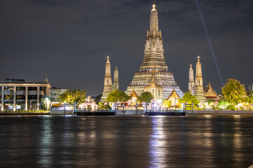 Naklejka premium Wat Arun (Temple of Dawn) as seen across the Chao Phraya River at night - Bangkok, Thailand