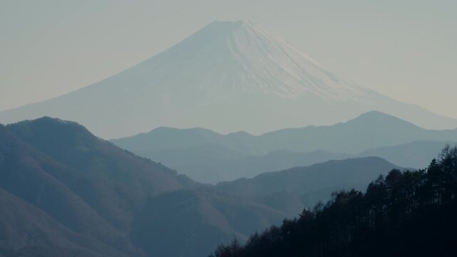 Classic Fuji view captured through mountain silhouettes and urban edge.