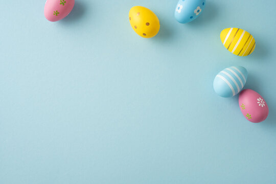 Happy Easter greeting featuring pastel decorated eggs on a soft blue background for spring celebration and seasonal decoration