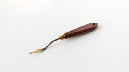 Sharp metal palette knife with wooden handle, side view. Art supplies for oil and acrylic painting