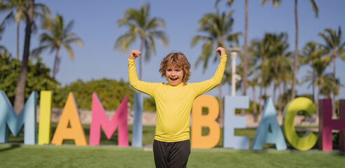 Child near Miami Beach sign. Happy kid enjoying summer in Miami. Kid near Miami Beach letters. Summer travel child. Summer outdoor kid portrait in Miami.