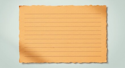 Fototapeta premium A piece of orange lined paper with rough, torn deckle edges on a light blue-grey surface.