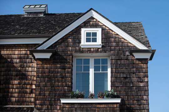House with cedar shingles feels inviting. Your classic house facade with a bright window looks clean. Their traditional house with a flowerbox adds charm.