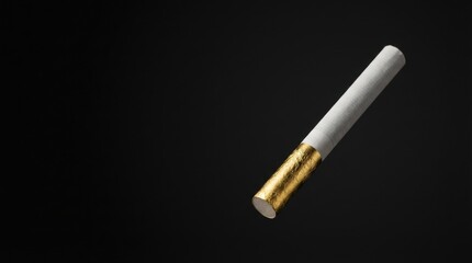 Single white cigarette featuring a shimmering gold wrapped filter against a plain dark background A studio photograph