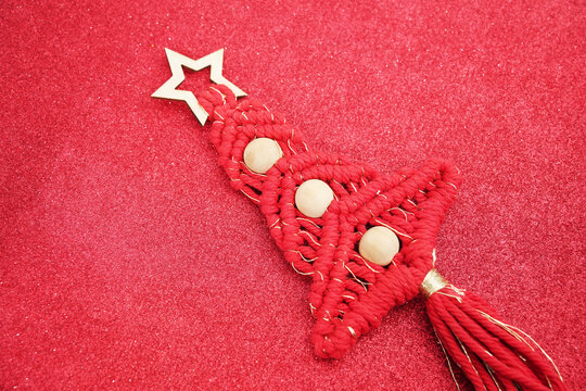 red Weaving christmas tree decration with bead on red glitter texture background with sequins and sparkles