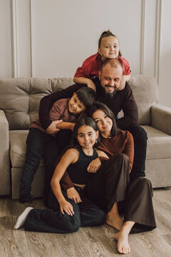 Happy family relaxing together on a couch at home, smiling and hugging