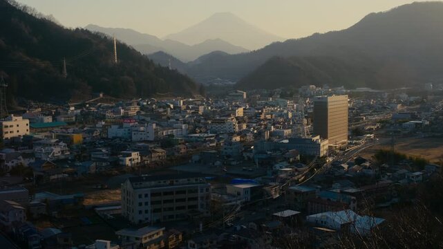 Daytime scenic view of Mount Fuji beyond Otsuki urban landscape.