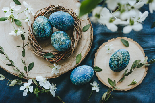 Blue Easter eggs dyed with hibiscus in rustic nest and floral decoration