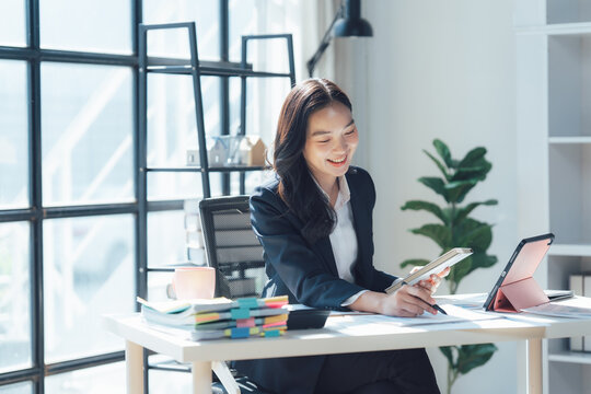 Busy Woman at Work: An accomplished businesswoman, deep in thought, sits at her desk, engrossed in analyzing data and formulating strategies for success.