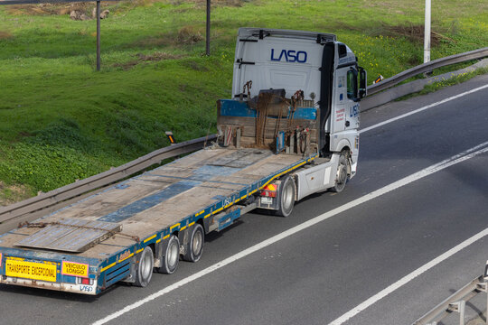 Laso truck transporting empty flatbed trailer on highway