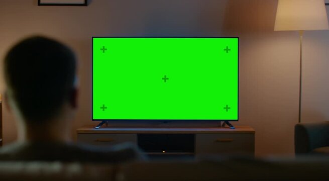 Man Watching TV with Green Screen &ndash; Living Room Television Chroma Key Mockup 4K
