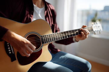 Obraz premium Strumming melodies in sunlight by the window in a cozy room