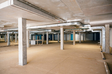 Naklejka premium Industrial basement interior with concrete pillars and ventilation ducts